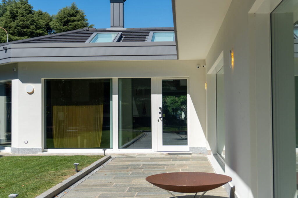 Vista dall'esterno di una villa moderna con porta blindata vetrata.