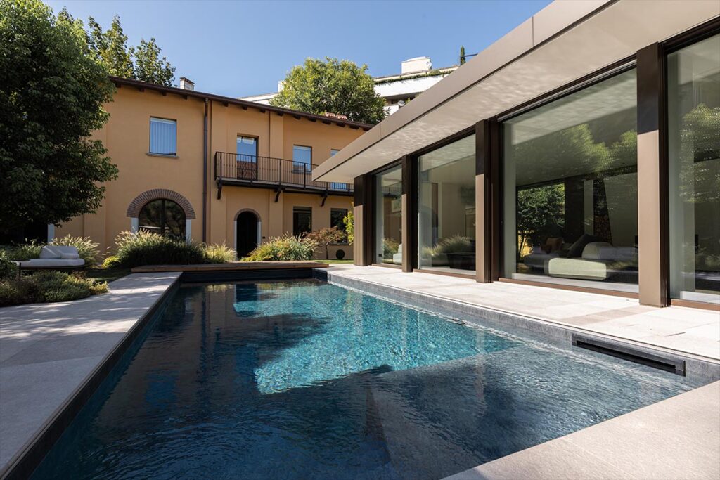 Infissi blindati di design in vetro per una villa a Milano con piscina.